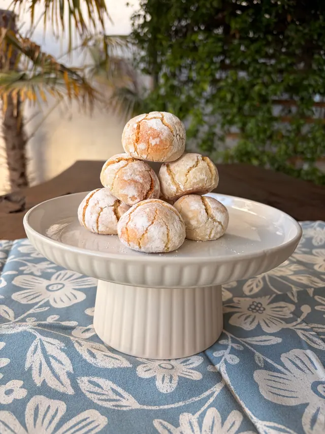 Forever Favourites_Almond Kiss cookies stacked on a cake stand outdoors.