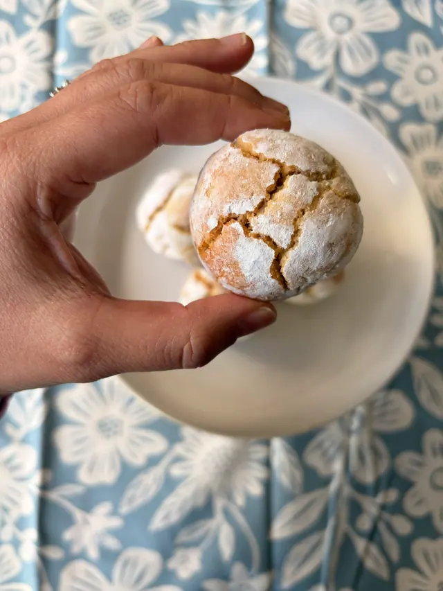 A close-up of a Forever Favourites_Almond Kiss cookie with its powdered sugar finish.