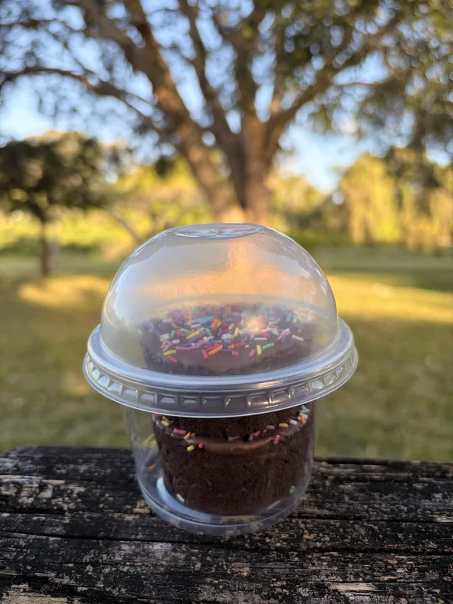 Round glazed Fudgy Brownies with colourful sprinkles packaged in a clear dessert cup.
