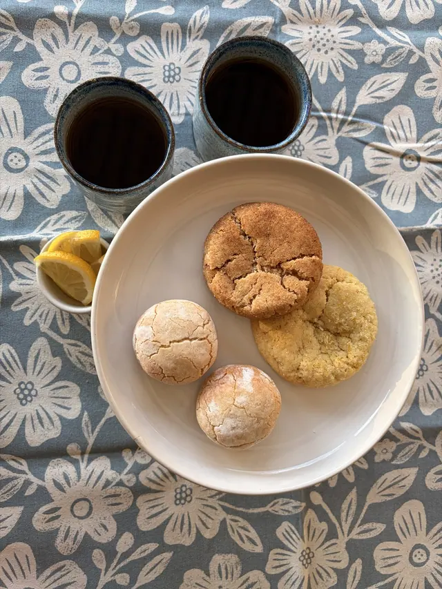 Cinnamon Hug, Almond Kiss, and Zesty Cookies arranged as individual favourites beside tea.