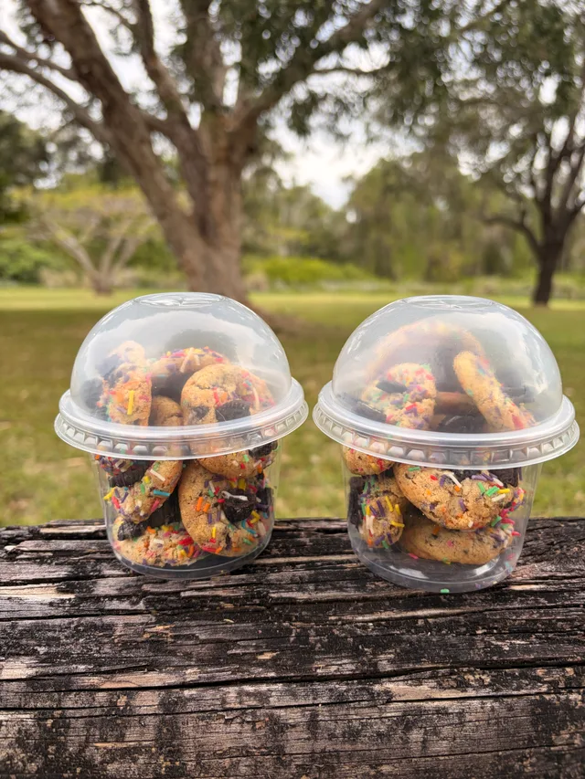 Two sharing cups filled with Happy Cookie Yummy Bites outdoors.